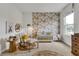 Bright Bedroom featuring floral wallpaper, a crib, a rocking chair, and a large dresser at 5789 Timber Meadow Way, St Cloud, FL 34771