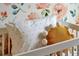 Close up of a white crib with a mustard colored pillow and patterned bedding in a Bedroom at 5789 Timber Meadow Way, St Cloud, FL 34771