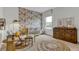 Charming Bedroom featuring floral wallpaper, a white crib with yellow accents, and a rocking chair at 5789 Timber Meadow Way, St Cloud, FL 34771