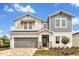 Charming two-story home featuring a gray and white exterior, covered entry, and a two-car garage at 5789 Timber Meadow Way, St Cloud, FL 34771