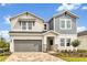 Charming two-story home featuring a gray and white exterior, covered entry, and a two-car garage at 5789 Timber Meadow Way, St Cloud, FL 34771