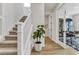 Hallway featuring a staircase, view into an office, and light-colored wooden floors at 5789 Timber Meadow Way, St Cloud, FL 34771