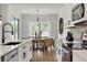 Bright kitchen with stainless steel appliances, white cabinets, dining table and pendant lighting near the window at 5789 Timber Meadow Way, St Cloud, FL 34771