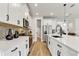 Modern kitchen with white cabinetry, stainless steel appliances, large island, and wood-look tile flooring at 5789 Timber Meadow Way, St Cloud, FL 34771