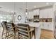 Modern kitchen featuring white cabinets, a backsplash, stainless steel appliances, and stylish pendant lights at 5789 Timber Meadow Way, St Cloud, FL 34771