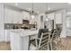 Modern kitchen with white cabinetry, stainless steel appliances, large island, and stylish pendant lighting at 5789 Timber Meadow Way, St Cloud, FL 34771