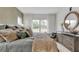 Cozy main bedroom featuring a large window, wood dresser and decorative, round mirror at 5789 Timber Meadow Way, St Cloud, FL 34771