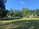 Expansive backyard view showing the home, pavilion and green grass at 24645 Ne 177Th Ter, Fort Mc Coy, FL 32134