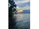 Waterfront view of a calm lake with a dramatic cloudscape at sunset at 24645 Ne 177Th Ter, Fort Mc Coy, FL 32134