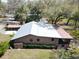 Aerial view of the home highlighting the metal roof, screened porch, and fenced backyard at 9461 Cr 657, Bushnell, FL 33513