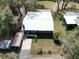 Aerial view of a home with a metal roof and a carport, set on a lot with mature trees at 9461 Cr 657, Bushnell, FL 33513