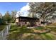 Exterior view of the home highlighting the back deck, screened-in porch, and a well-manicured lawn at 9461 Cr 657, Bushnell, FL 33513
