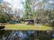 Water view from a fenced backyard with a lush lawn and mature trees at 9461 Cr 657, Bushnell, FL 33513