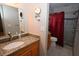 This bathroom features a granite vanity countertop, cherry wood cabinets, and a tiled shower with a red curtain at 9461 Cr 657, Bushnell, FL 33513