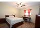 Cozy bedroom with wood floors, ceiling fan, desk, and a large window at 9461 Cr 657, Bushnell, FL 33513
