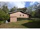 Side view of the home featuring a metal roof, a storage shed and well-maintained landscaping at 9461 Cr 657, Bushnell, FL 33513