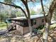 Exterior view of the home showing screened porch, wooden deck, and a fenced yard at 9461 Cr 657, Bushnell, FL 33513