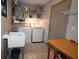 Functional laundry room includes washer, dryer, sink, storage shelves, and a convenient folding table at 9461 Cr 657, Bushnell, FL 33513