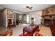 Bright living room with a stone fireplace, tile floor, and view into the kitchen and dining area at 9461 Cr 657, Bushnell, FL 33513