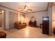 Living room with tile floors, ceiling fan, and a comfortable leather sofa at 9461 Cr 657, Bushnell, FL 33513