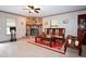 Cozy living area featuring a stone fireplace, ceiling fan, and classic furnishings on tile floor at 9461 Cr 657, Bushnell, FL 33513