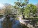 Scenic view of a tranquil waterfront property with mature trees and a cozy picnic area at 9461 Cr 657, Bushnell, FL 33513
