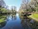 Picturesque waterfront with a covered dock offering serene views of the calm water and surrounding trees at 9461 Cr 657, Bushnell, FL 33513