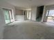 Open-concept living area with sliding glass doors, stairs, and an unfinished floor at 222 Carpenters Way # 68, Lakeland, FL 33805