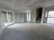 Open-concept living area with sliding doors, staircase, and unfinished flooring at 222 Carpenters Way # 68, Lakeland, FL 33805