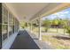 Long covered porch perfect for relaxing, featuring classic columns, and a serene view of the surroundings at 15675 Sw 33Rd St, Ocala, FL 34481