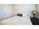 Comfortable bedroom featuring a bed with a patterned quilt, a nightstand, and a door at 2723 Elmbrooke Way, Edgewater, FL 32141