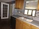A bright kitchen featuring wood cabinets, tile backsplash, and stainless steel dishwasher at 4801 Avon St, Lake Wales, FL 33859