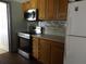Bright kitchen featuring stainless steel appliances, tiled backsplash, and wood cabinets at 4801 Avon St, Lake Wales, FL 33859