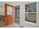 Entryway featuring a modern orange front door, adjacent window, and luxury vinyl plank flooring at 524 Marion Oaks Blvd, Ocala, FL 34473