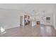 Open-concept living room and kitchen area features modern light fixtures, stainless steel appliances, and wood-look flooring at 524 Marion Oaks Blvd, Ocala, FL 34473