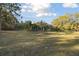 This home boasts a large grassy backyard with mature trees and tropical plants, including a screened-in pool area at 5261 Waterwood Dr, Bartow, FL 33830