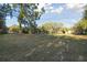 Expansive backyard featuring a large grassy area, mature trees, and an enclosed screened porch, perfect for outdoor activities at 5261 Waterwood Dr, Bartow, FL 33830