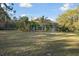 Expansive backyard featuring a screened-in pool area and well-maintained lawn surrounded by lush greenery at 5261 Waterwood Dr, Bartow, FL 33830