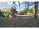 Mature trees decorate the grassy yard of this home, also showing a glimpse of the screened-in pool area at 5261 Waterwood Dr, Bartow, FL 33830