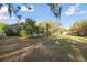 Picturesque backyard with lush landscaping, a screened-in pool area, and mature trees providing shade and privacy at 5261 Waterwood Dr, Bartow, FL 33830