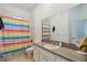 Bathroom with colorful striped shower curtain, a mirror, and white fixtures at 5261 Waterwood Dr, Bartow, FL 33830