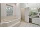 Bright bathroom features a soaking tub, tiled floor, and a vanity with a sink and ample counter space at 5261 Waterwood Dr, Bartow, FL 33830