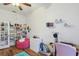 Bedroom with wood floors, pink beanbag chair, workspace desk, and large shelving unit at 5261 Waterwood Dr, Bartow, FL 33830