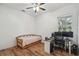 The bedroom is simply decorated and features a bed, computer desk, ceiling fan, and light wood floors at 5261 Waterwood Dr, Bartow, FL 33830