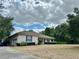 Charming single-story home with vinyl siding, a long driveway, and lush green surroundings under a bright blue sky at 5261 Waterwood Dr, Bartow, FL 33830