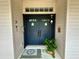 Close-up of front door with homey decor, including a wreath and potted plant at 5261 Waterwood Dr, Bartow, FL 33830