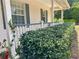 Charming porch lined with vibrant green hedges and white railings, creating a welcoming entrance at 5261 Waterwood Dr, Bartow, FL 33830