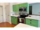 Bright kitchen features green cabinets, stainless steel appliances, and tiled backsplash at 5261 Waterwood Dr, Bartow, FL 33830