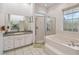 Bright bathroom featuring a soaking tub, glass enclosed shower, and neutral decor at 5261 Waterwood Dr, Bartow, FL 33830