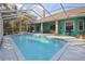 Inviting backyard pool is surrounded by a screened enclosure, patio, and brightly colored house at 5261 Waterwood Dr, Bartow, FL 33830